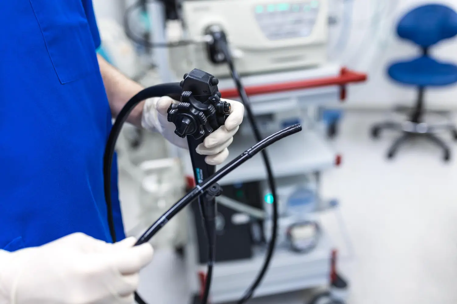 Endoscópio sendo segurado por um médico com luvas brancas, representando o exame de endoscopia e seu uso diagnóstico e terapêutico.